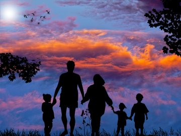 A picture of a family staring at a sunset.